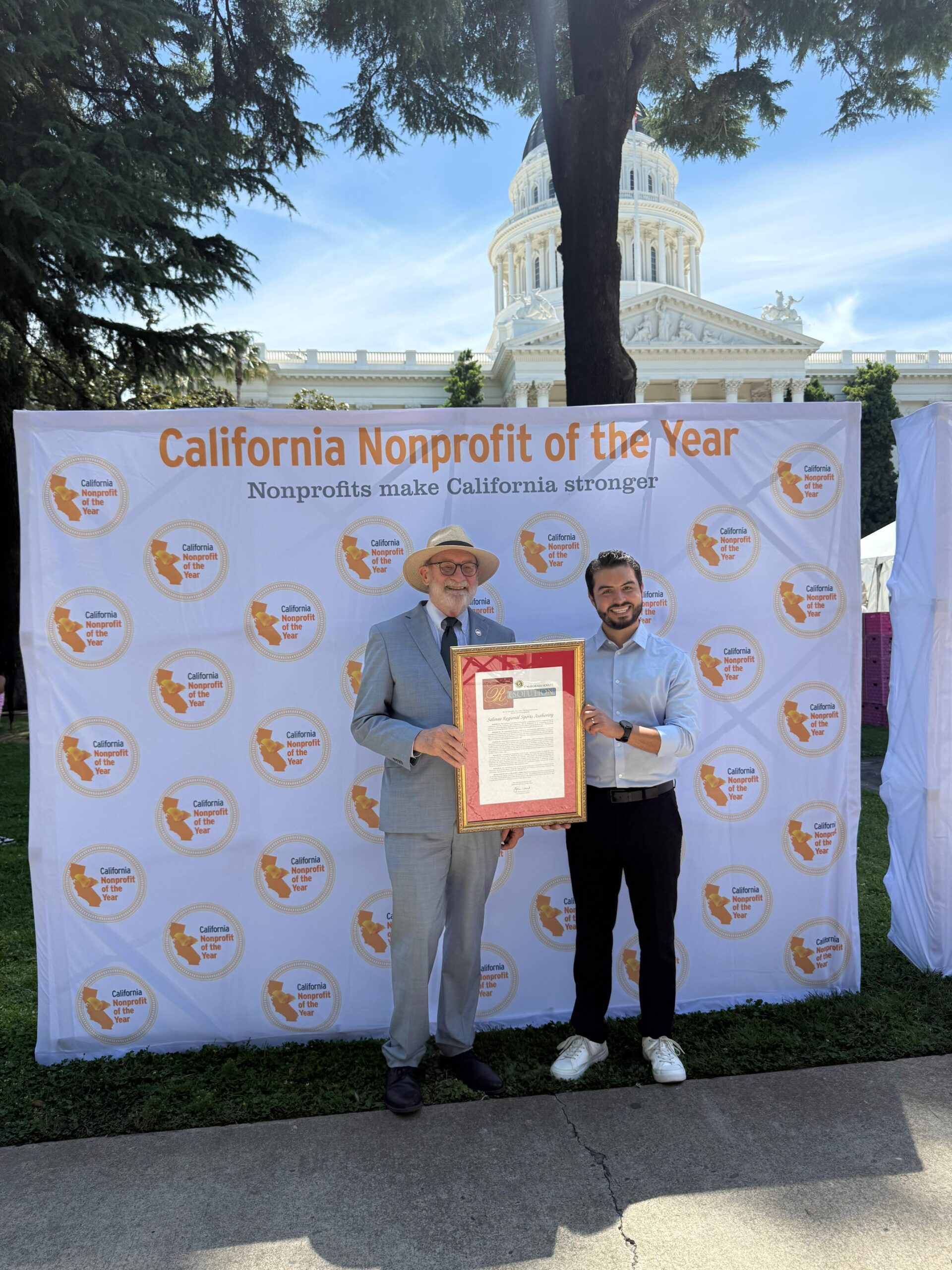 Senator John Laird and Jonathan De Anda holding Non-profit of the year award.