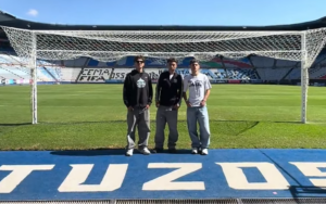 Soccer players from Salinas, California are standing on a soccer field at the Universidad del Fútbol y Ciencias del Deporte.